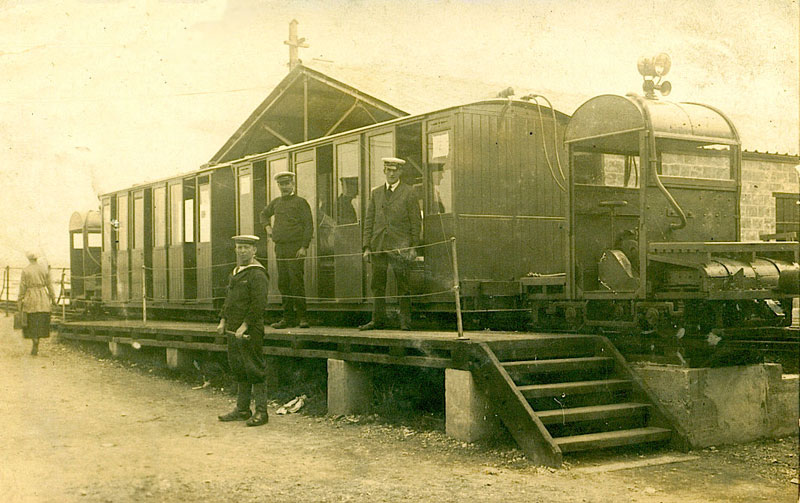 An early 1920s photo showing two carriages, and a tractor on each end.